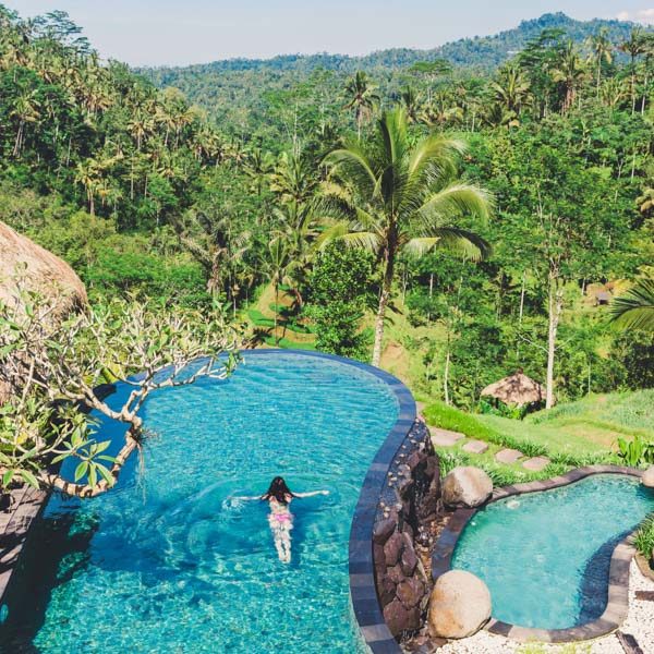 Girl is swimming in a large beautiful pool against the backdrop